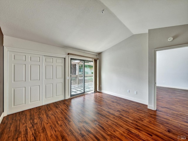 unfurnished bedroom with wood finished floors, baseboards, vaulted ceiling, access to outside, and a closet