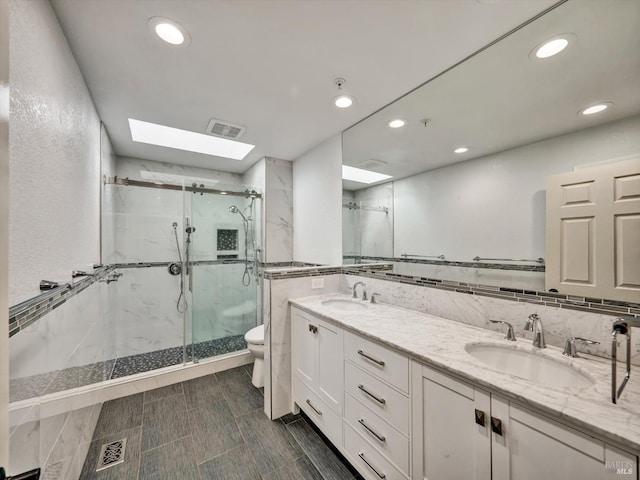 full bath with toilet, a marble finish shower, a sink, and visible vents