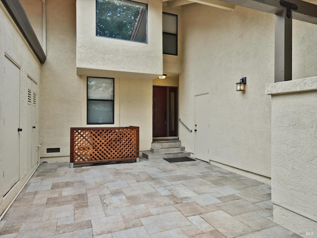 property entrance with a patio and stucco siding