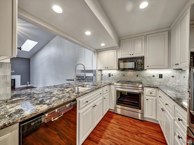 kitchen featuring a skylight, wood finished floors, a sink, white cabinets, and black appliances