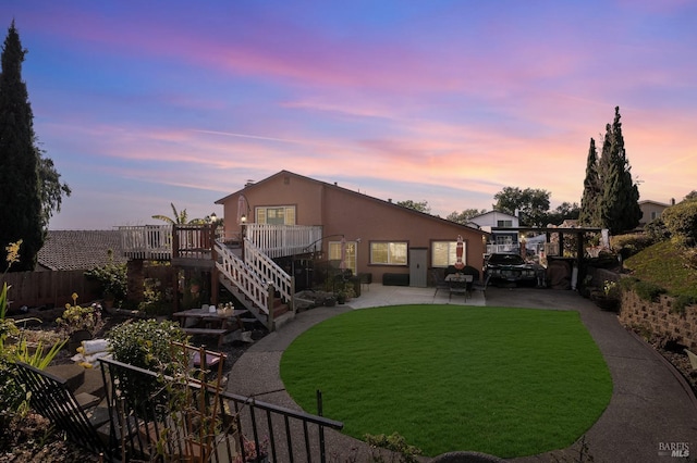 back of house with a yard, a patio, stucco siding, a deck, and stairs