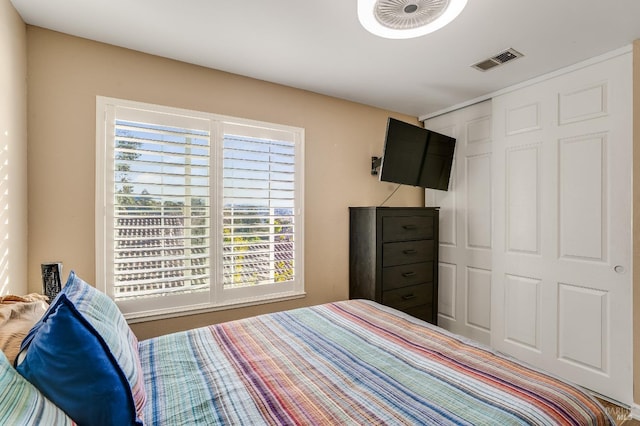 bedroom featuring multiple windows, visible vents, and a closet