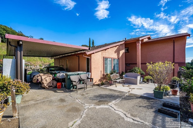 rear view of property featuring a patio area and stucco siding