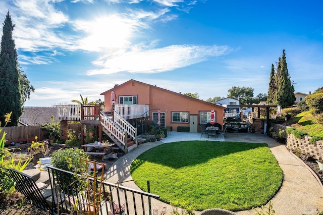 back of property featuring a yard, a patio, stucco siding, stairway, and fence