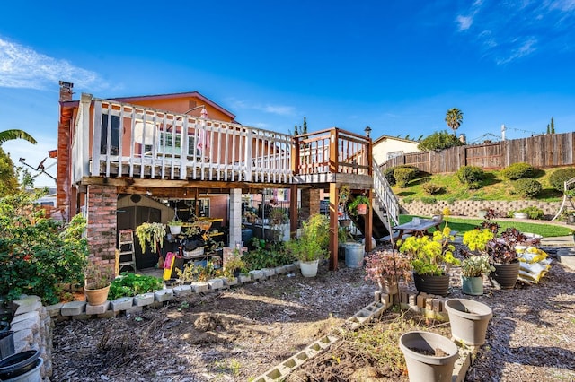 back of property with a deck, fence, and stairway