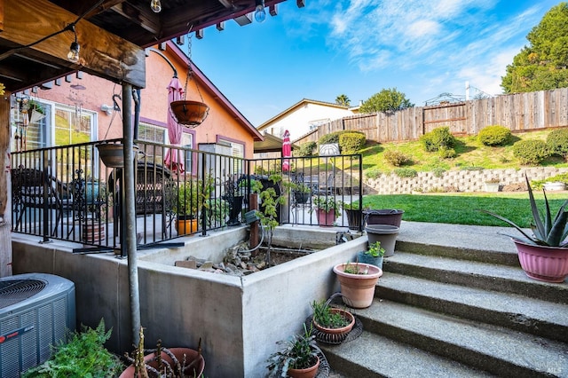 view of patio / terrace with cooling unit and fence