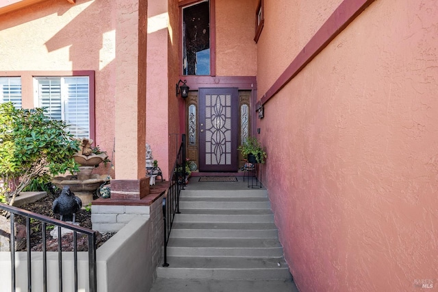 entrance to property with stucco siding