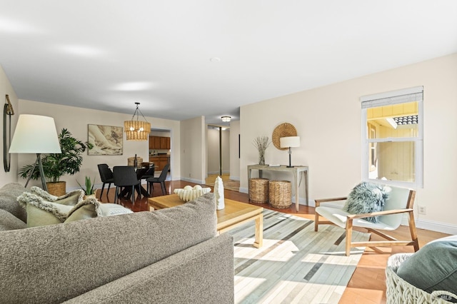 living room featuring a chandelier, light wood-style floors, and baseboards