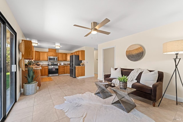 living room featuring light tile patterned floors, a ceiling fan, and baseboards