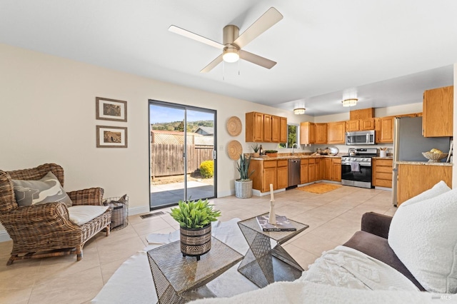 living room featuring light tile patterned floors, ceiling fan, visible vents, and baseboards