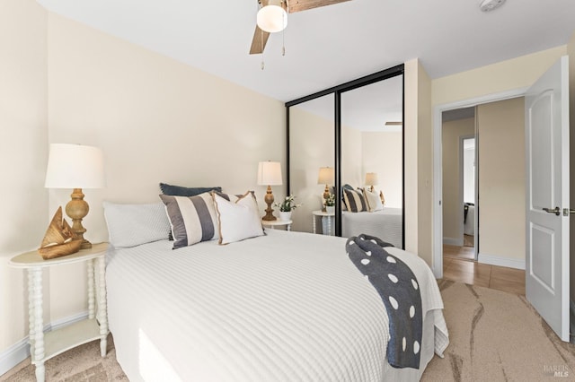 bedroom with a closet, baseboards, a ceiling fan, and light tile patterned flooring