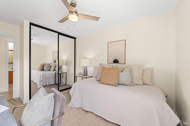 bedroom featuring a ceiling fan, a closet, light carpet, and baseboards