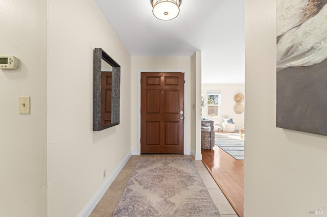 corridor with light wood-style flooring and baseboards