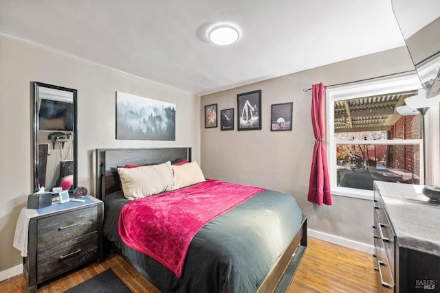 bedroom with baseboards and wood finished floors