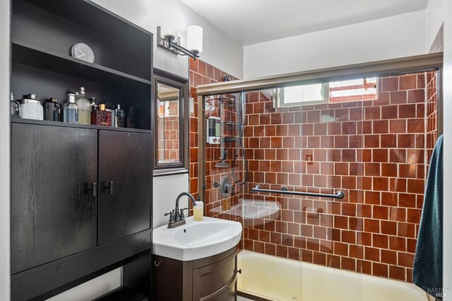 bathroom with shower / bath combination with glass door and vanity