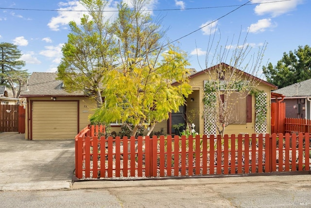 view of front facade featuring a fenced front yard, a garage, and concrete driveway