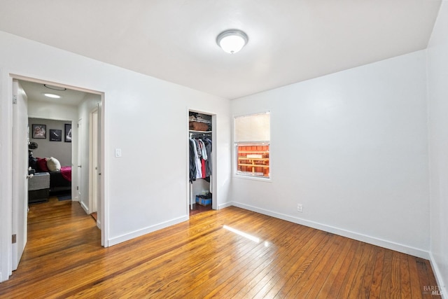 unfurnished bedroom featuring a closet, baseboards, and light wood-style flooring