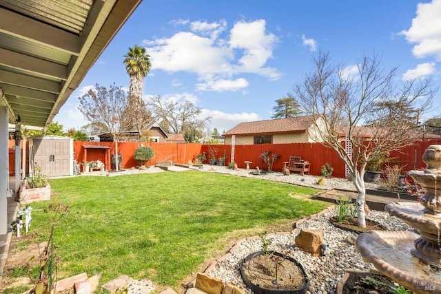 view of yard with a fenced backyard, an outbuilding, and a storage shed