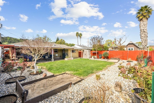 view of yard featuring a garden, fence private yard, and a patio area
