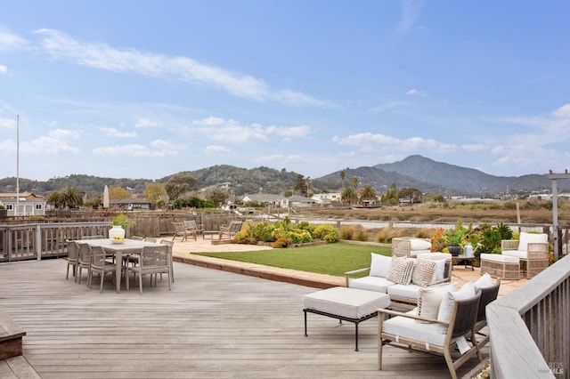 wooden terrace with outdoor dining space, outdoor lounge area, and a mountain view