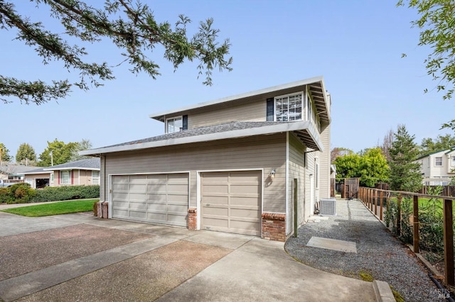 view of front of house featuring a garage, driveway, brick siding, and fence