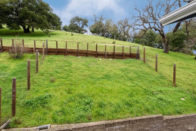 view of yard with a rural view and fence