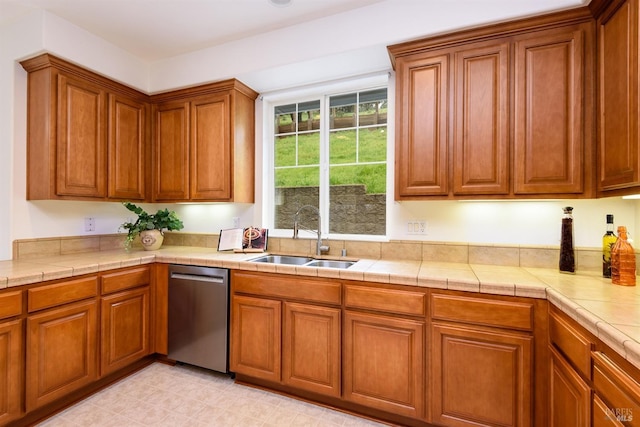 kitchen featuring brown cabinets, a sink, and stainless steel dishwasher