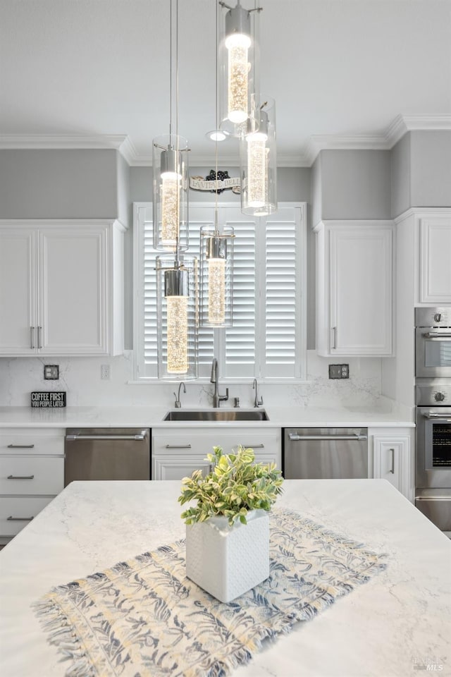 kitchen featuring a warming drawer, crown molding, stainless steel appliances, white cabinets, and a sink