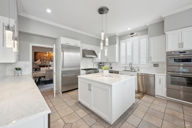 kitchen with white cabinets, a kitchen island, decorative light fixtures, stainless steel appliances, and under cabinet range hood