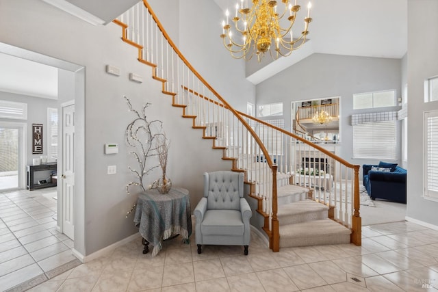 stairs featuring baseboards, tile patterned floors, a high ceiling, crown molding, and a chandelier