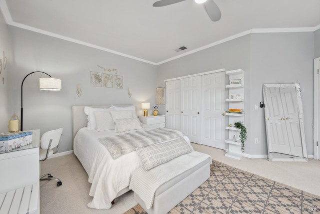 carpeted bedroom with baseboards, visible vents, a ceiling fan, and ornamental molding