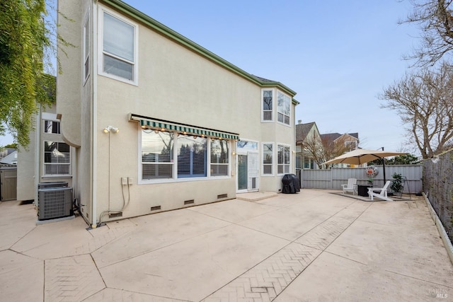 back of property featuring crawl space, stucco siding, a fenced backyard, and central AC unit