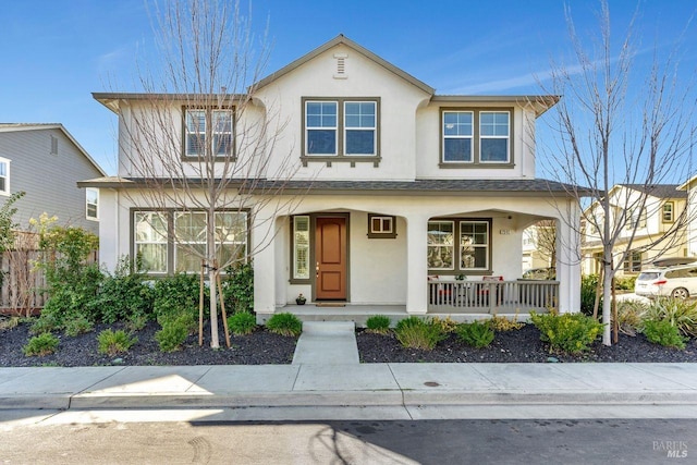 view of front of property featuring covered porch, stucco siding, roof with shingles, and fence