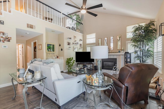 living room with baseboards, visible vents, ceiling fan, wood finished floors, and a fireplace