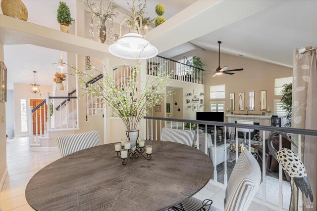 dining space with high vaulted ceiling, light tile patterned floors, stairway, and a ceiling fan