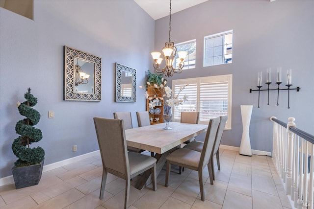 dining space with a notable chandelier, a high ceiling, and baseboards