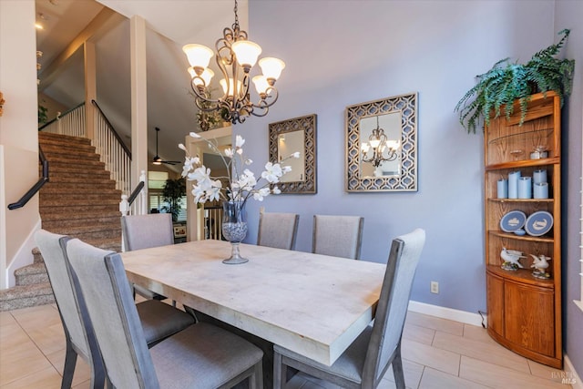 dining area featuring ceiling fan with notable chandelier, light tile patterned floors, baseboards, and stairs