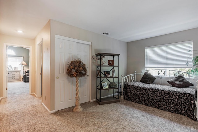 bedroom with light colored carpet, a closet, visible vents, and baseboards