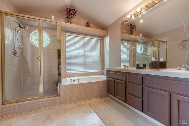 bathroom featuring double vanity, a bath, a tile shower, vaulted ceiling, and a sink