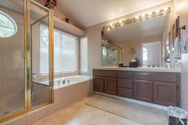 full bath featuring double vanity, a shower stall, vaulted ceiling, and a bath