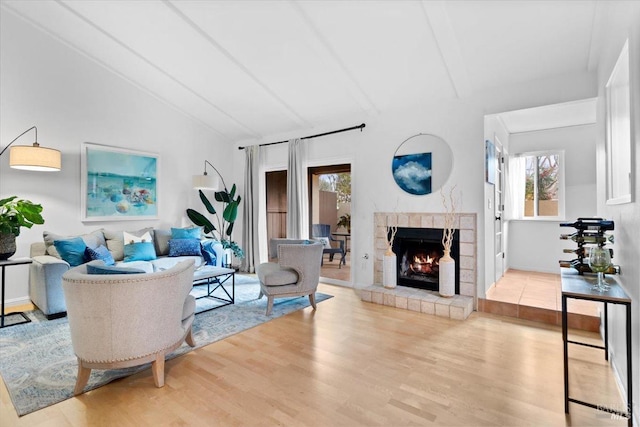 living room with lofted ceiling, wood finished floors, visible vents, and baseboards