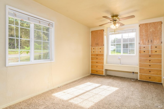 unfurnished bedroom with carpet, a ceiling fan, and baseboards