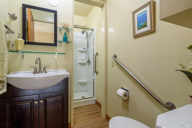 full bath with toilet, a shower stall, wood finished floors, and vanity