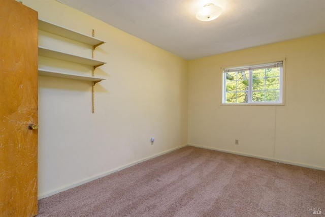 carpeted spare room featuring baseboards