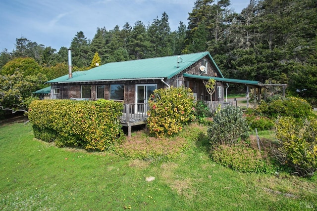 view of front facade featuring a carport, a front yard, and metal roof