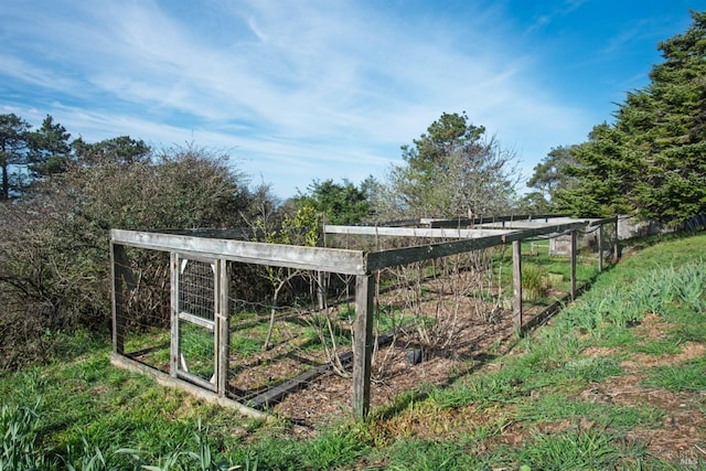 view of outbuilding featuring fence and a vegetable garden