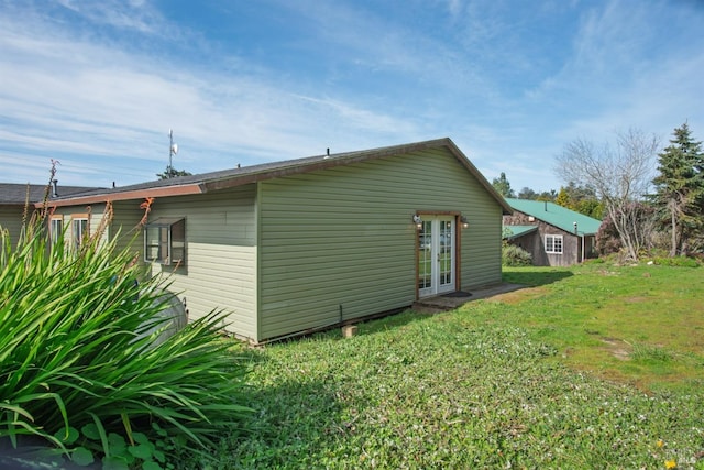 back of property featuring french doors and a lawn