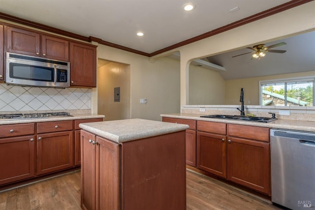 kitchen featuring dark wood finished floors, stainless steel appliances, light countertops, decorative backsplash, and a sink