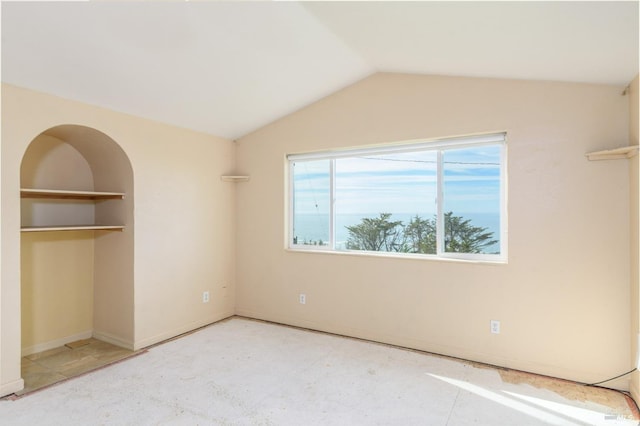 unfurnished bedroom featuring baseboards, vaulted ceiling, and a closet