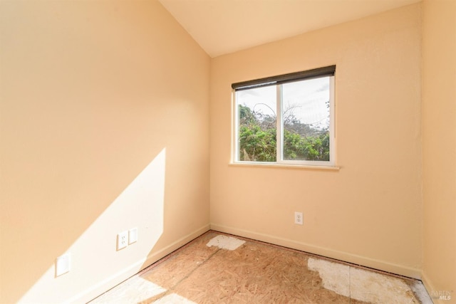 empty room with lofted ceiling and baseboards